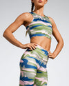 Camufarre Sustainable Sports Crop with racer back design. Featuring a one off camo activewear print created with a purpose by Scultura. Inspired by the ocean and designed to raise awareness of the environmental impact of single use plastic. Created with premium technical Italian fabric made with 100% regenerated yarn from recycled plastic bottles (rPET). Side View.