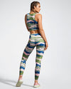 Model Wearing Camufarre Sustainable Gym Leggings. Featuring a one off camo activewear print created with a purpose by Scultura. Inspired by the ocean and designed to raise awareness of the environmental impact of single use plastic. Created with premium technical Italian fabric made with 100% regenerated yarn from recycled plastic bottles (rPET). Back view.