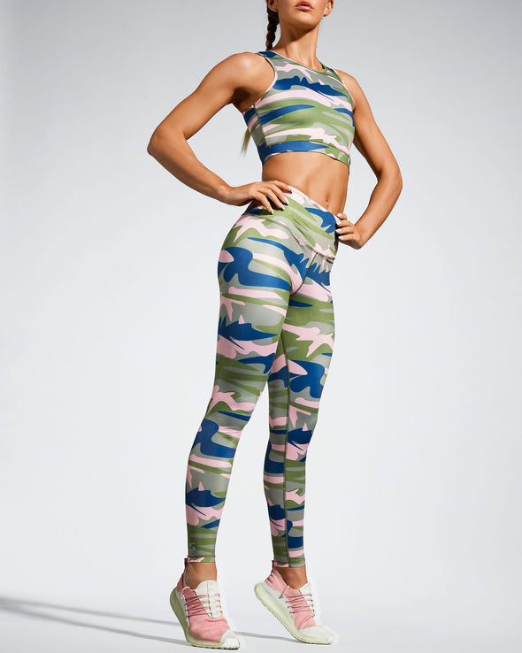Model wearing Camufarre Sustainable Gym Leggings. Featuring a one off camo activewear print created with a purpose by Scultura. Inspired by the ocean and designed to raise awareness of the environmental impact of single use plastic. Created with premium technical Italian fabric made with 100% regenerated yarn from recycled plastic bottles (rPET). Front view.
