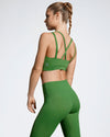 Model wearing green sustainable Flusso gym bra. Ladies Sustainable Activewear made to last with premium Italian sports tech fabric created with ECONYL Regenerated Yarn.  Side view.