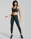 New Horizons Sienna Gym Leggings Print. Women in dark blue and burnt orange sienna print sports bra and gym leggings. Made of recycled fabric created with yarn from pre and post consumer materials such as plastic bottles.