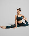 Women in yoga pose wearing sports bra and leggings in Sienna activewear print. Made with sustainable sportswear fabric.