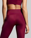 Close up back view of burgundy berry gym leggings. Designed in the UK with fabric made with ECONYL® regenerated yarn.