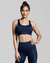 Navy blue sustainable gym wear set. Sports bra and leggings made with ECONYL® regenerated yarn. Navy blue sports bra with crossover straps.