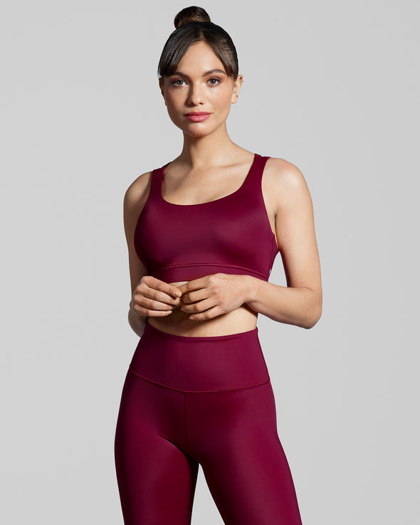 Women wearing New Horizons gym leggings and sports bra in true berry. Luxury sustainable gym set. Gym leggings and sports bra in wine red.