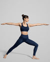 Women wearing deep blue yoga leggings and sports crop bra. Dark blue sustainable activewear. 